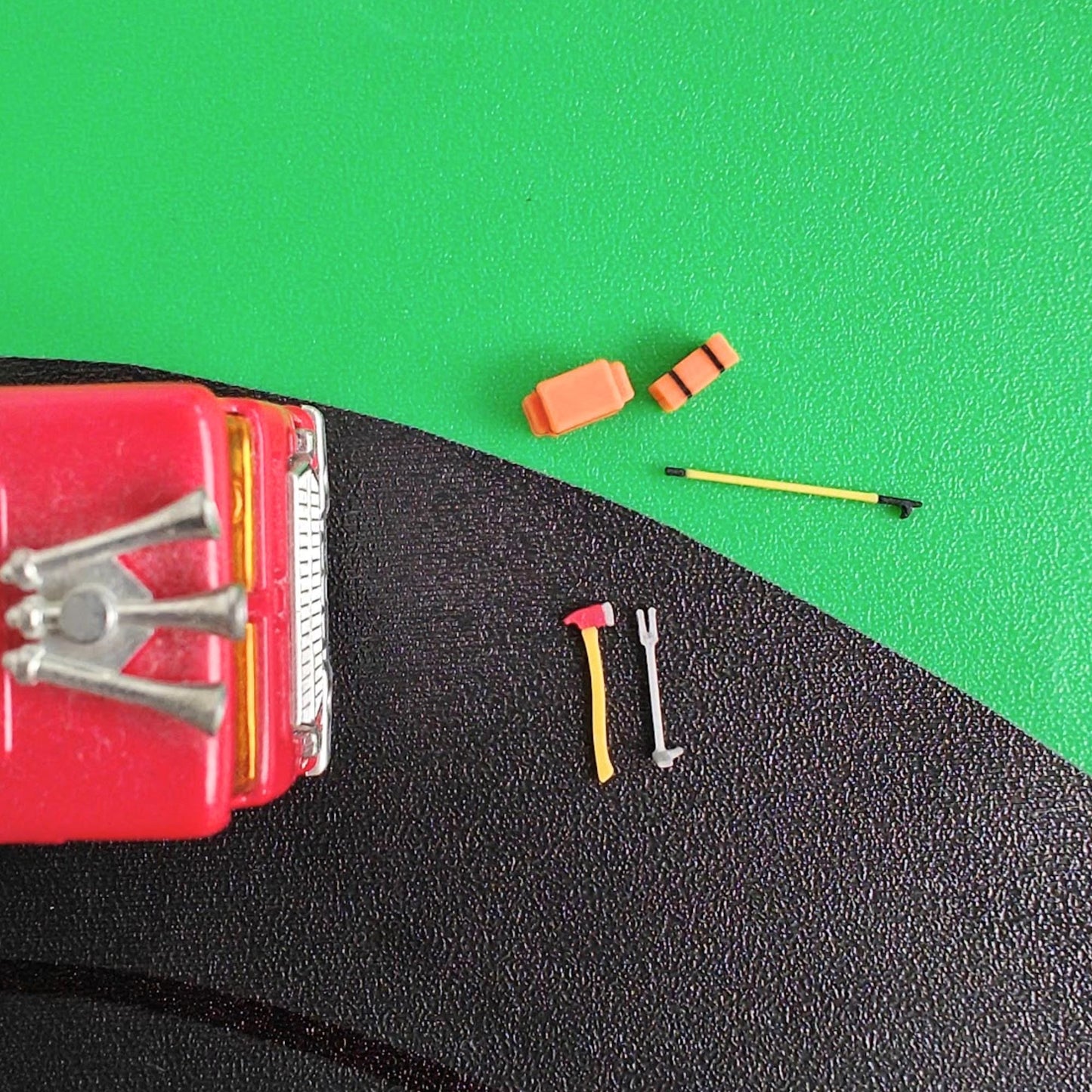 Firefighter rescue tools set placed near fire truck hood in 1/64 scale scene