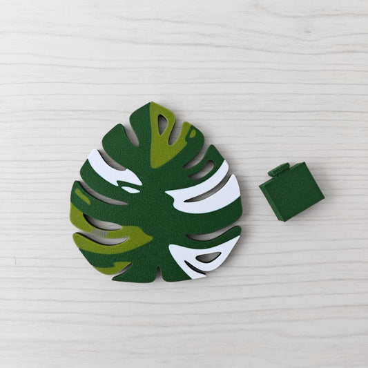 Front view of the Monstera leaf handle in leaf green, venom green, and white with the separate green key cover piece placed beside it.