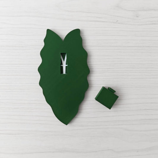 Back view of the solid green handle with the separate green cover piece placed beside it.