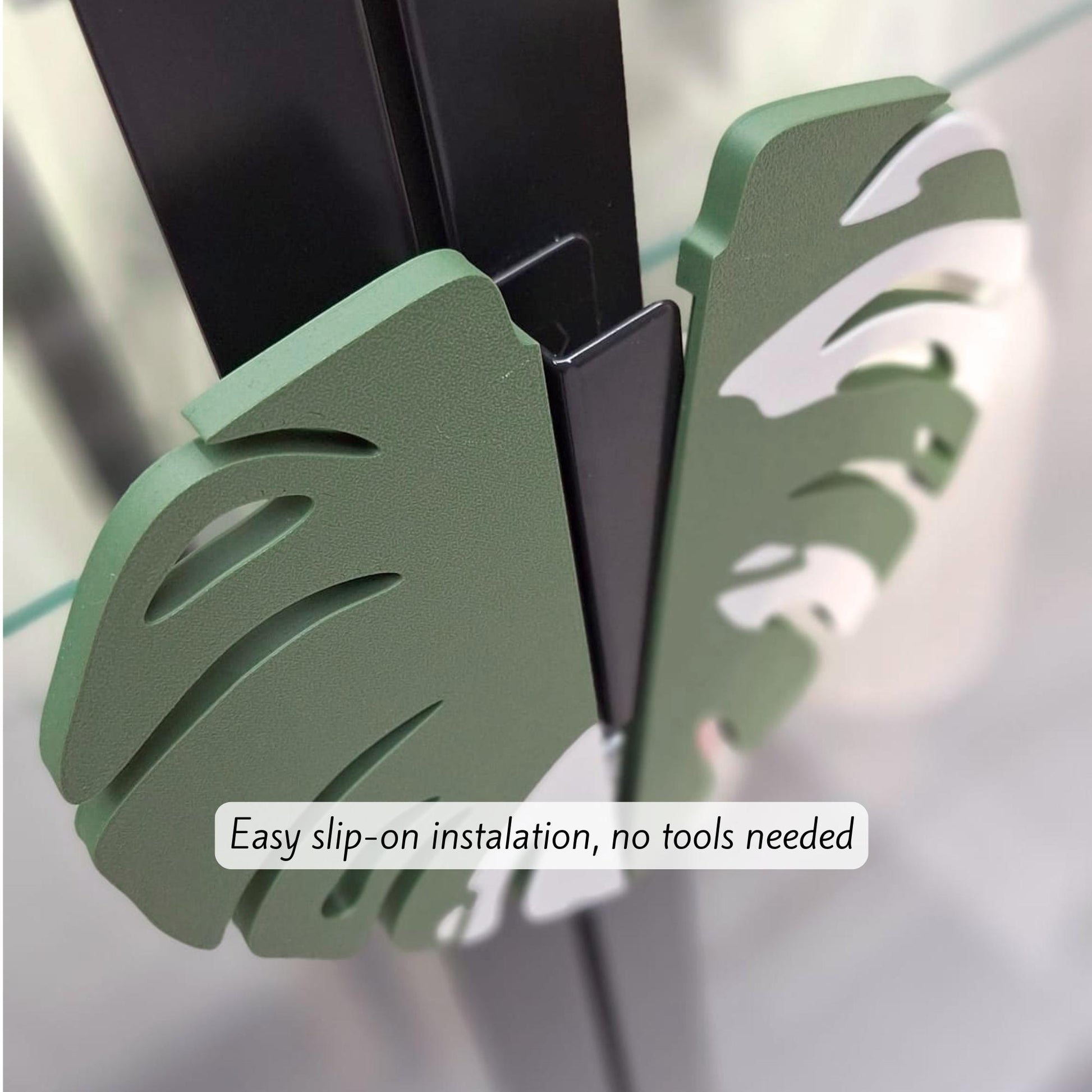 Close-up of slip-on plant-style cabinet handles installed on a black IKEA cabinet frame, showing tool-free installation.