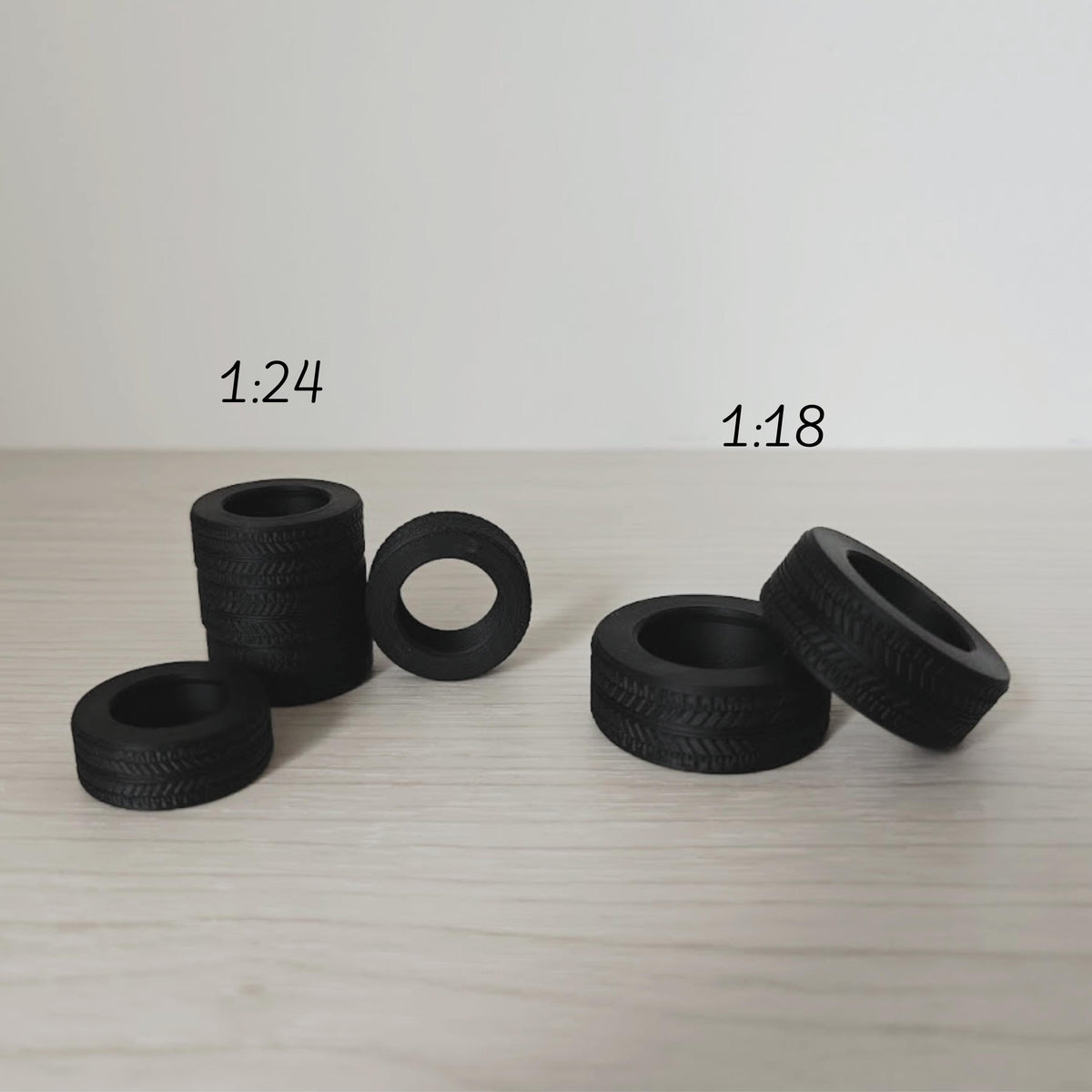 Miniature tires displayed in 1:24 and 1:18 scale side by side