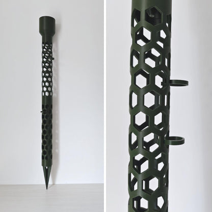 Close-up side view of dark green moss pole with hexagonal pattern, watering cap and clips attached.