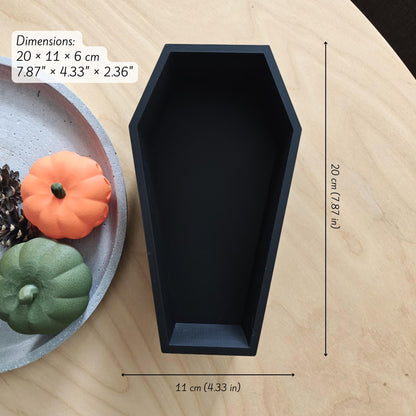 Empty black coffin tray with pumpkins beside it, labeled with size dimensions