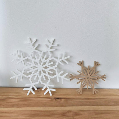 White and latte brown snowflake decorations displayed on a wooden shelf