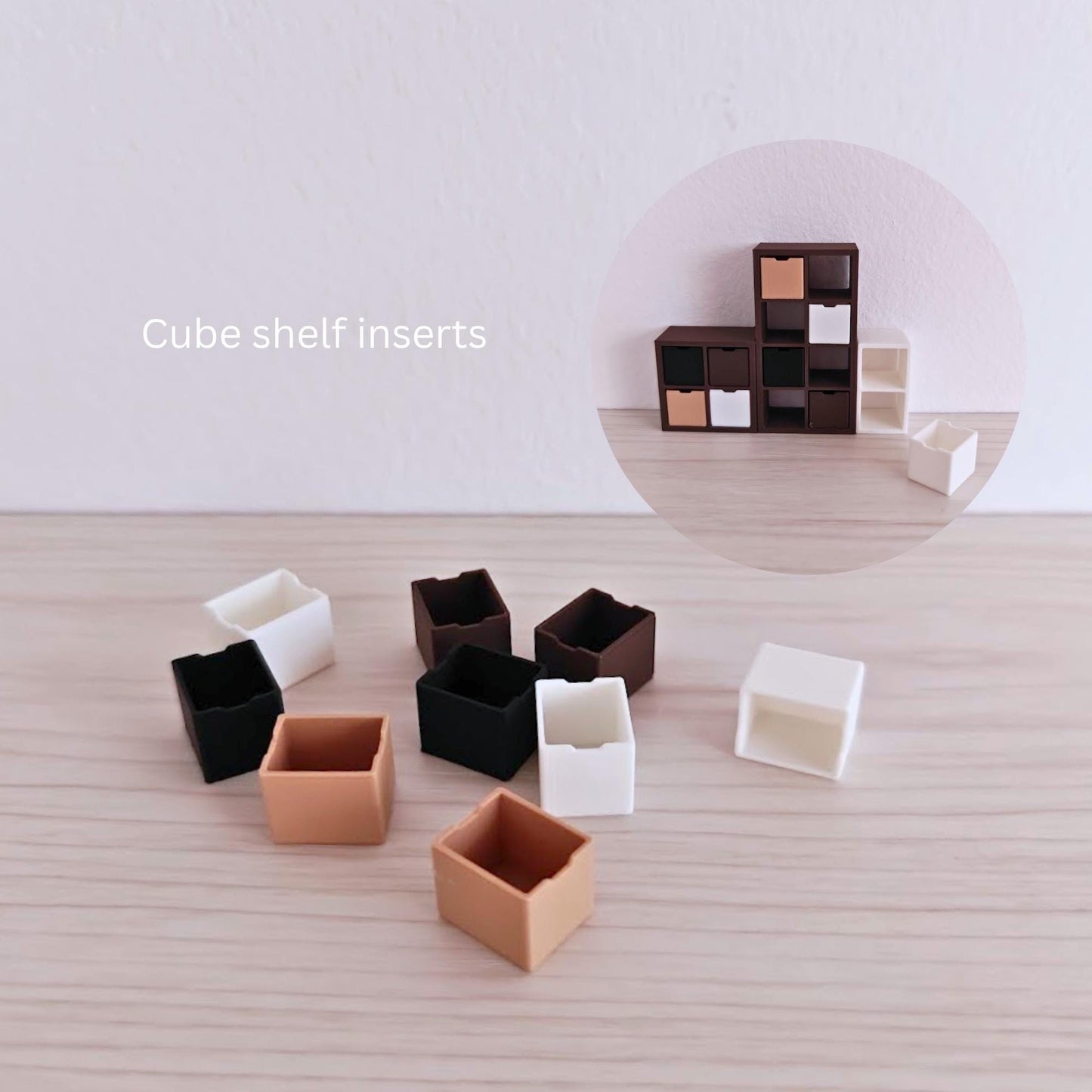 Close-up of 3D-printed cube shelf inserts in neutral and dark colors, suitable for miniature shelving units.