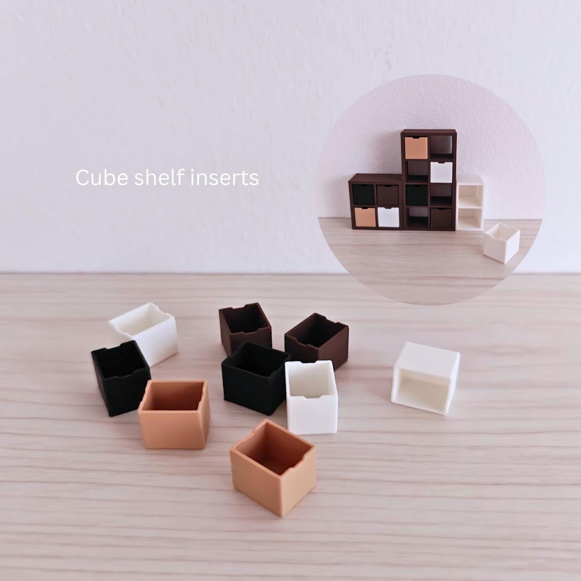 Close-up of 3D-printed cube shelf inserts in neutral and dark colors, suitable for miniature shelving units.