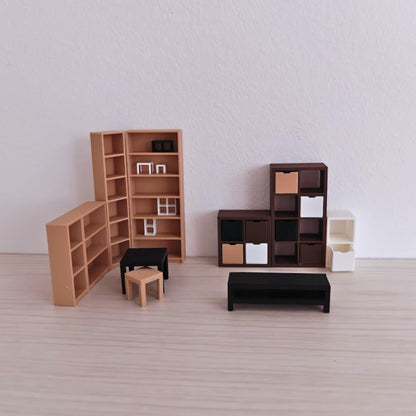 3D-printed miniature furniture collection with modern shelving and tables displayed on a light wood background.