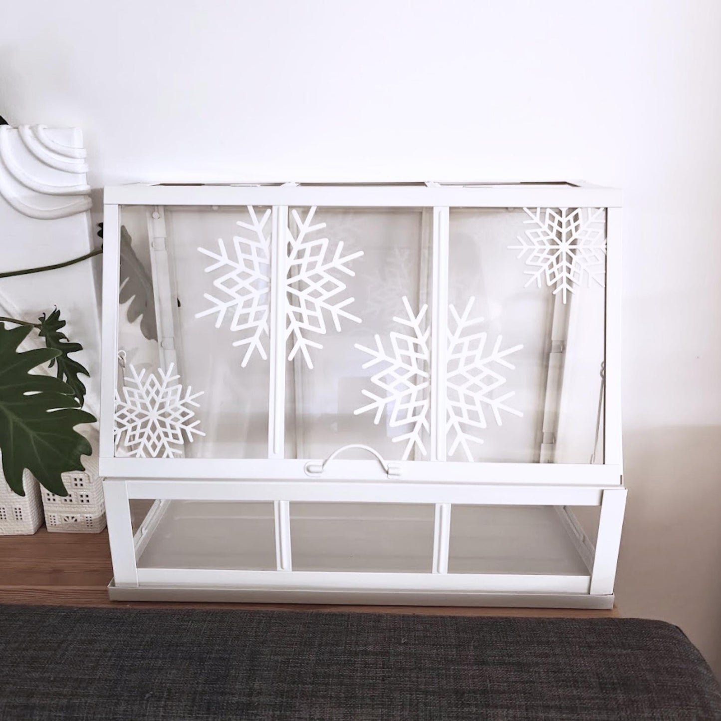 White Äkerbar greenhouse featuring multiple white snowflake decorations in bright room lighting.
