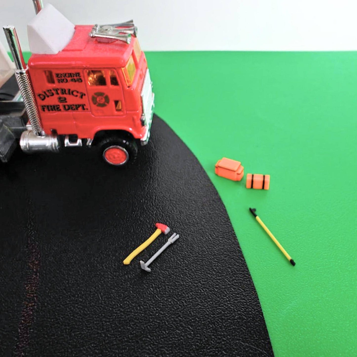 Firefighter tools set in 1/64 scale displayed beside fire truck for diorama scene
