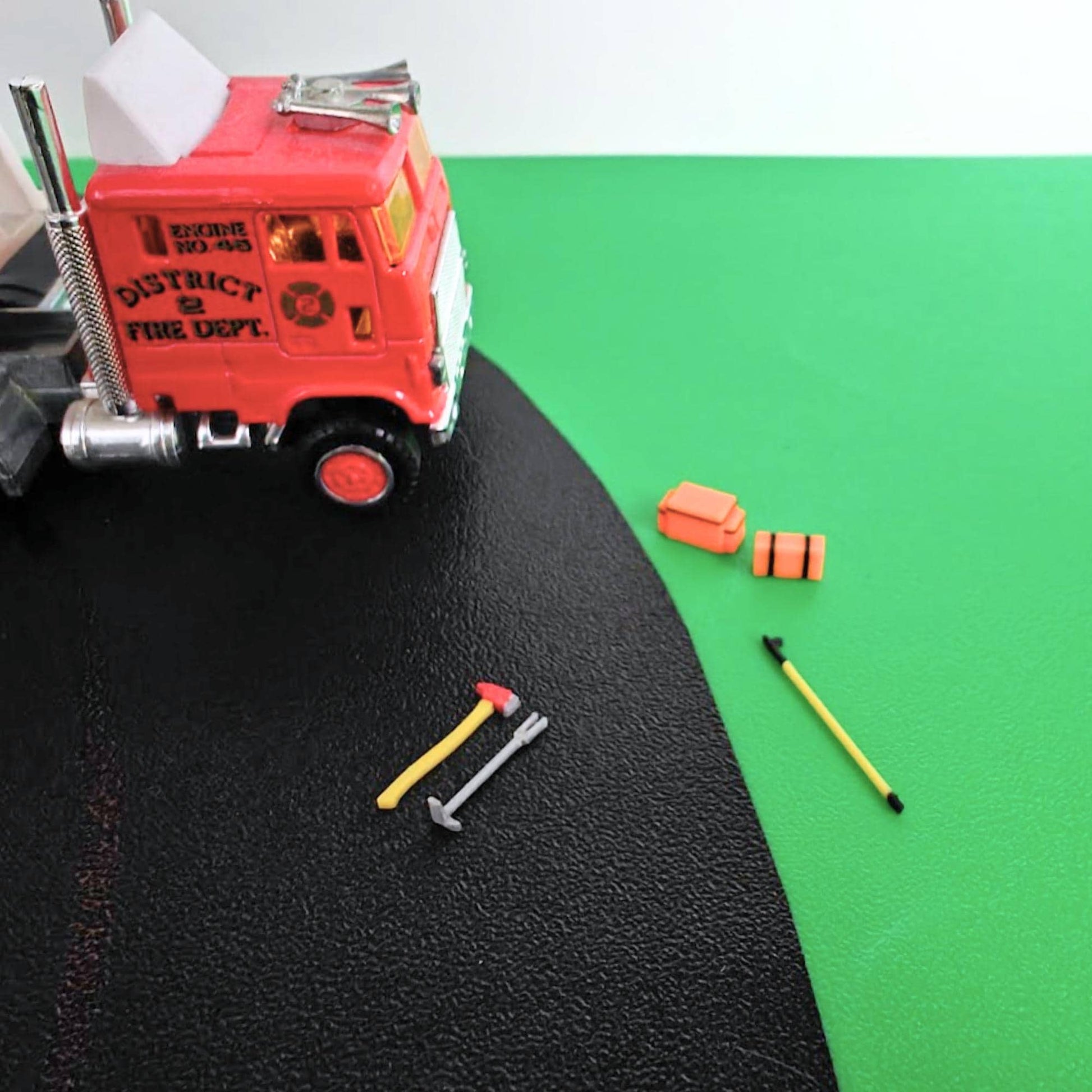 Firefighter tools set in 1/64 scale displayed beside fire truck for diorama scene