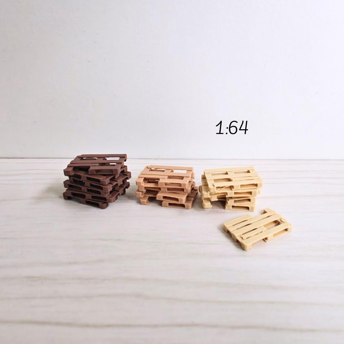 Small stack of miniature pallets in 1:64 scale with worn wood texture