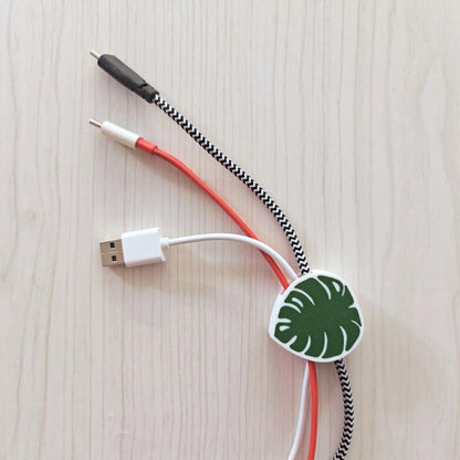 White-green monstera cable clip organizing multiple cords