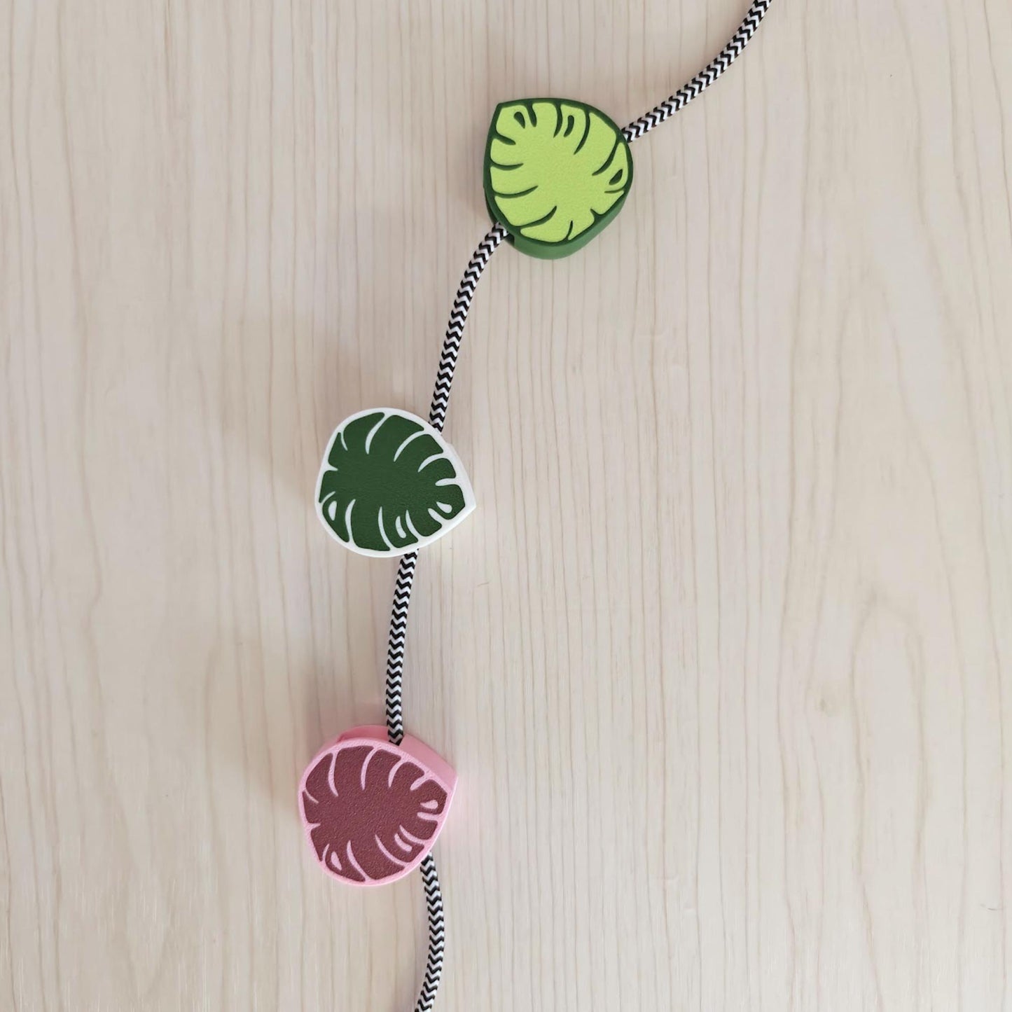 Monstera cable clips in different colors holding braided cord