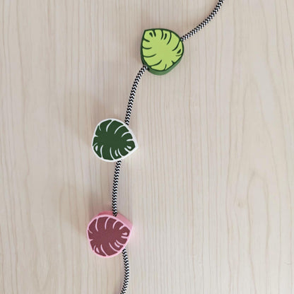 Monstera cable clips in different colors holding braided cord
