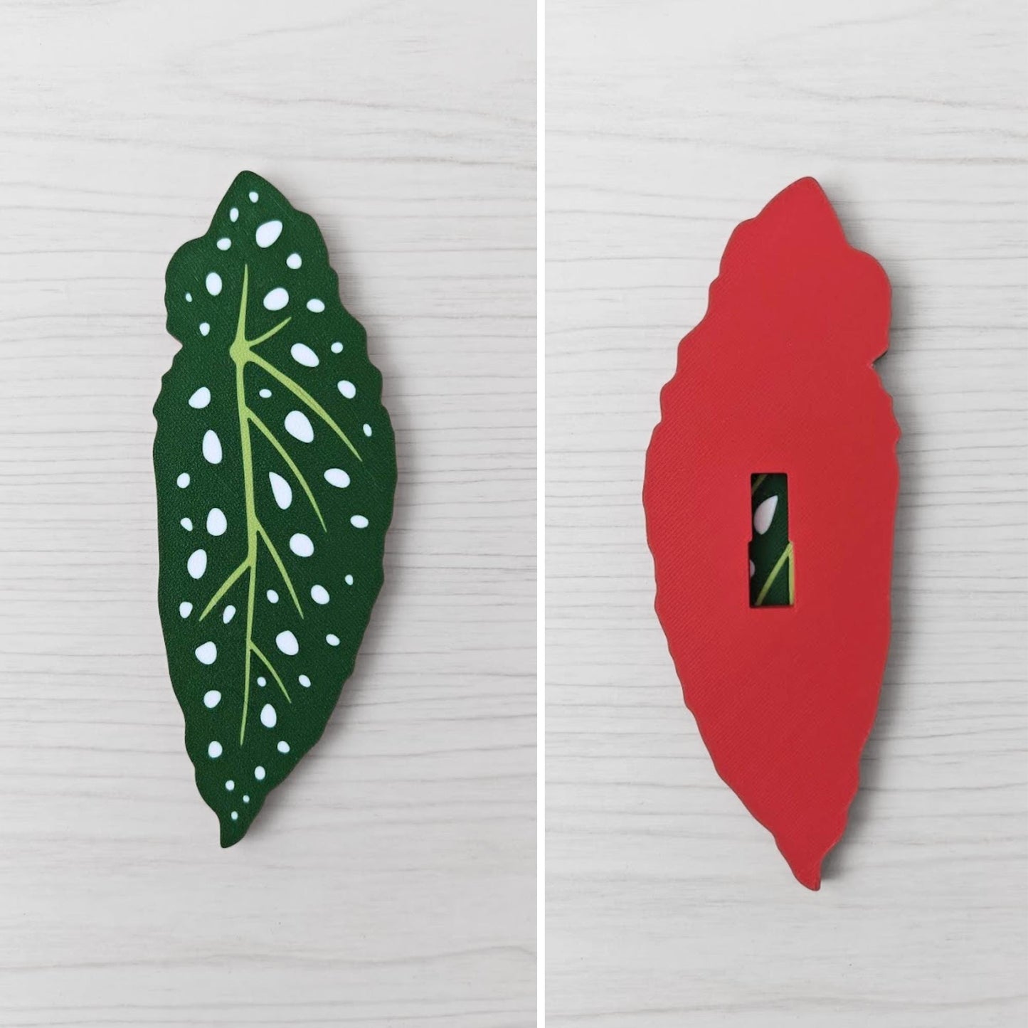 Front and back view of a Begonia leaf handle, showing the spotted green leaf front and red back with key slot opening.