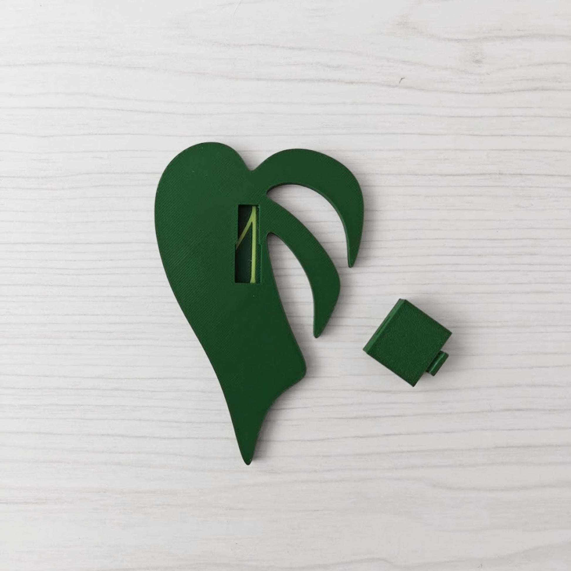 Back view of the handle showing the key slot opening, with the separate green cover piece placed beside it.