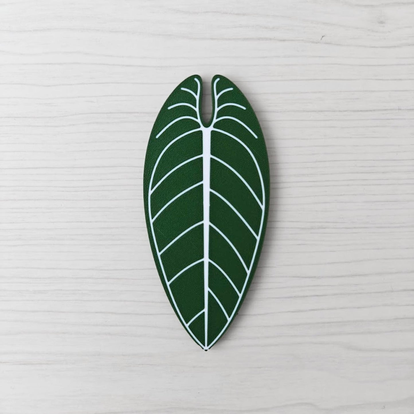 Front view of the Anthurium Warocqueanum key cover handle with white vein detail on a light wood background.
