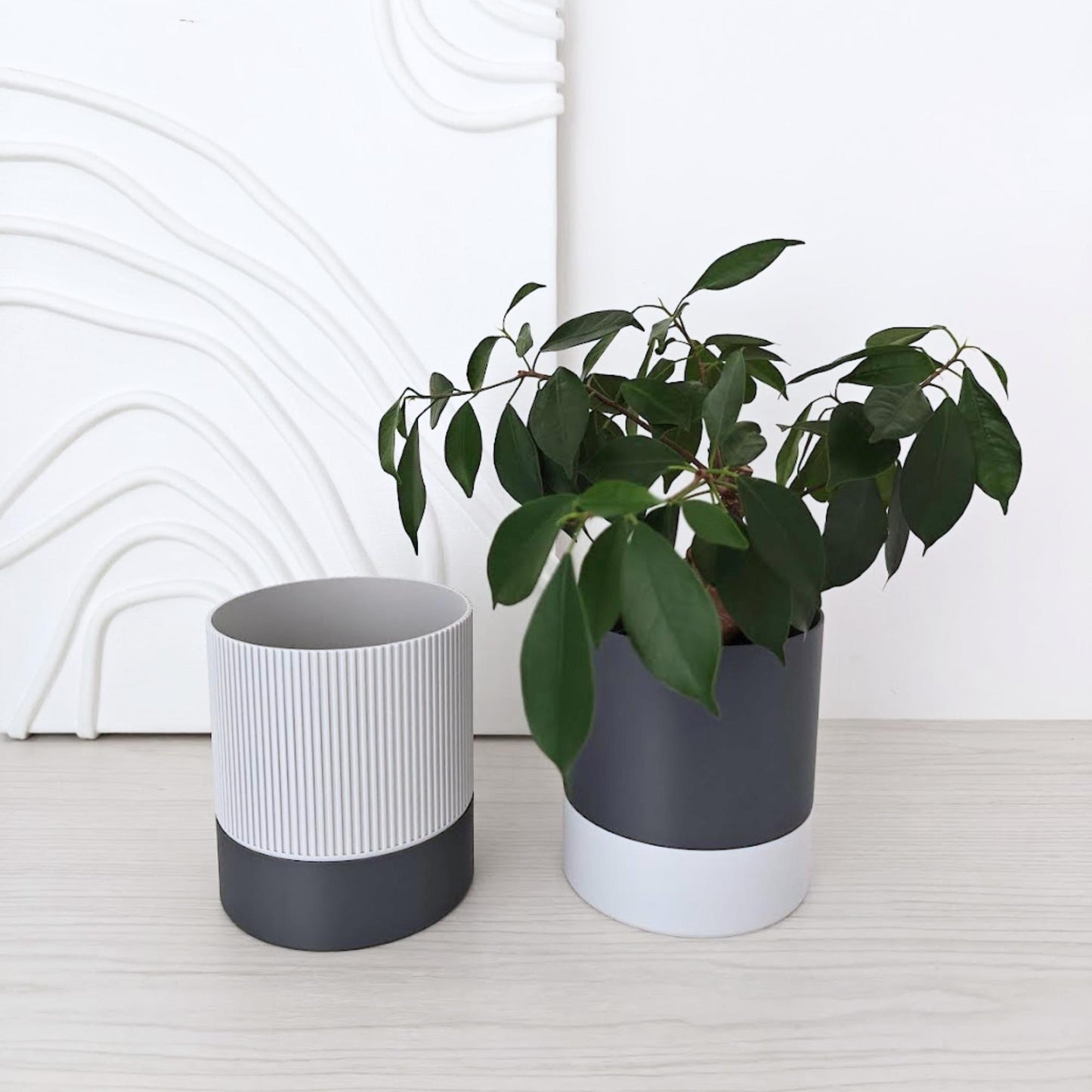 Self-watering planter shown with a plant inside, next to an empty ribbed inner pot and bottom water reservoir.