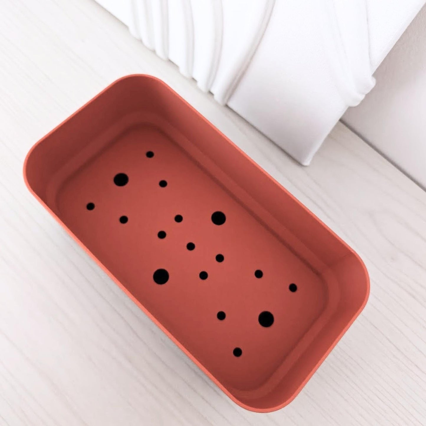 Angled top view of the rectangular inner pot with multiple drainage holes.