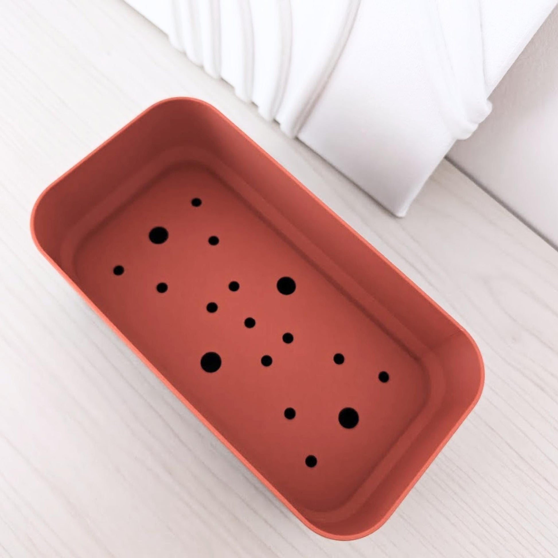 Angled top view of the rectangular inner pot with multiple drainage holes.