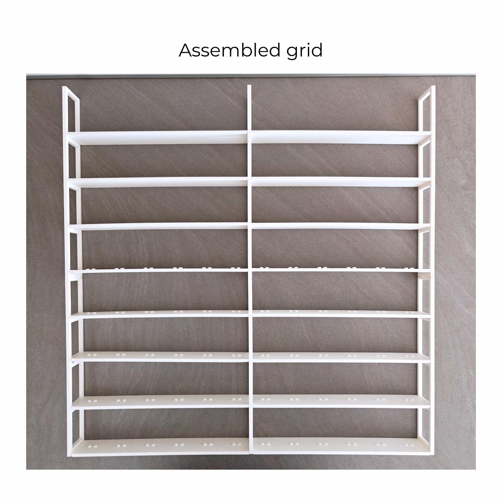 Fully assembled white LEGO minifigure grid insert shown outside the frame.