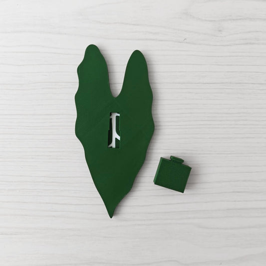 Back view of the handle showing the key slot opening, with the separate green cover piece placed beside it.