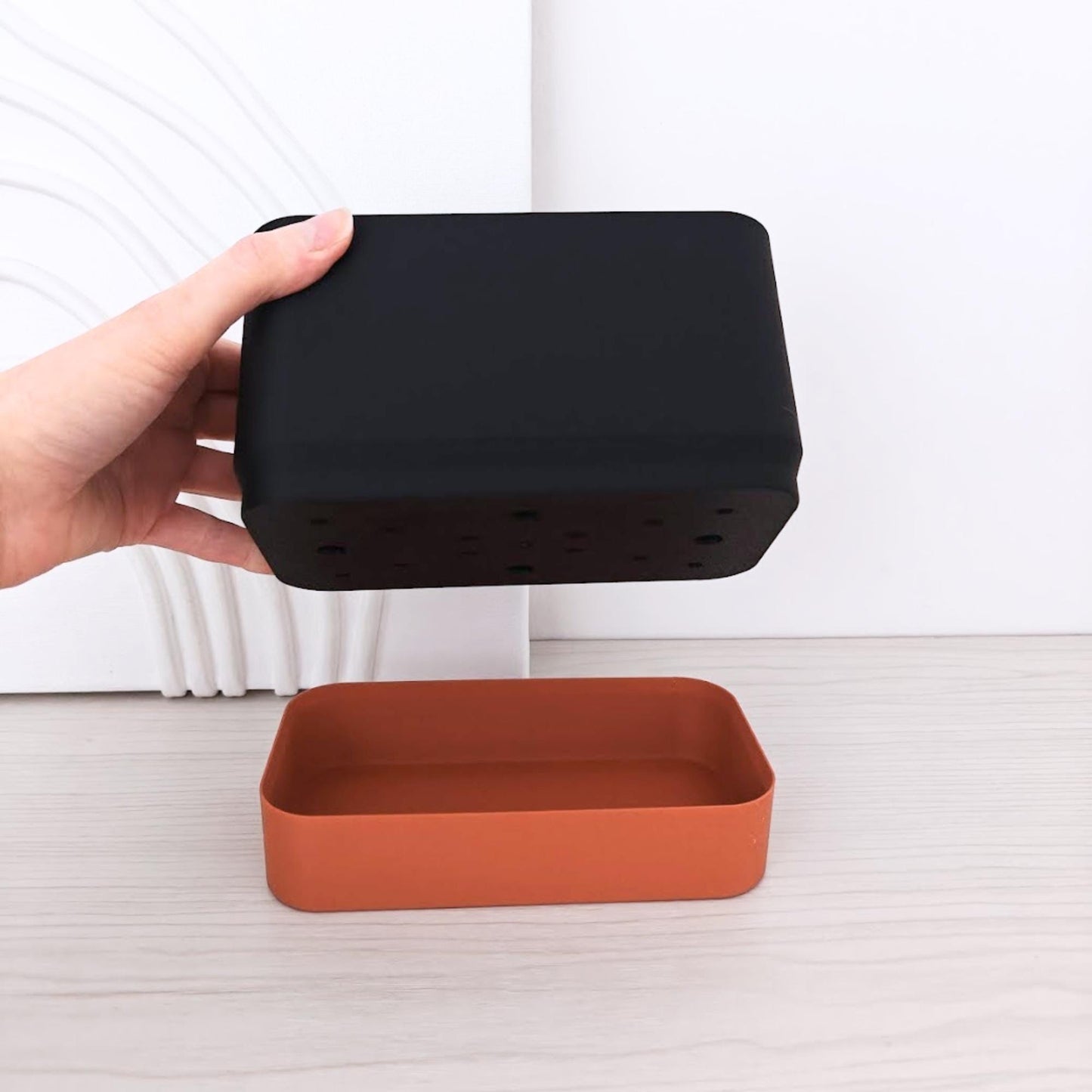 Demonstration photo showing the top planter section being lifted above the bottom water reservoir.