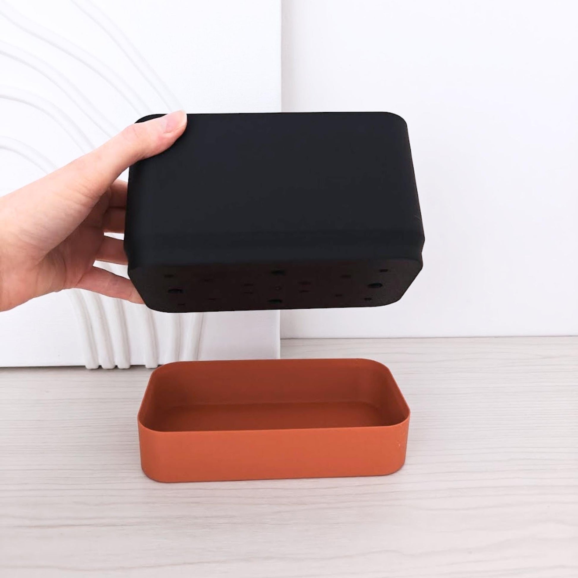 Demonstration photo showing the top planter section being lifted above the bottom water reservoir.