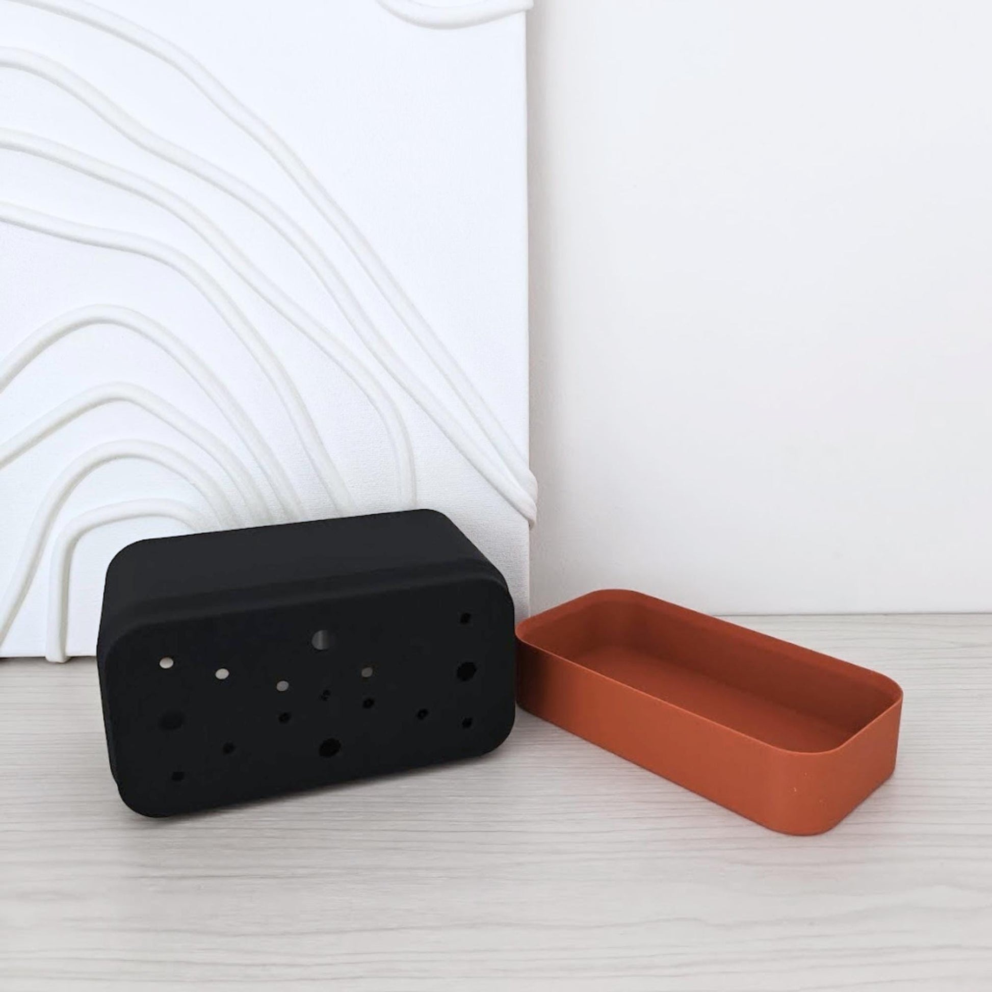 Separated view of the two planter parts placed on their sides, showing the inner pot and bottom reservoir.