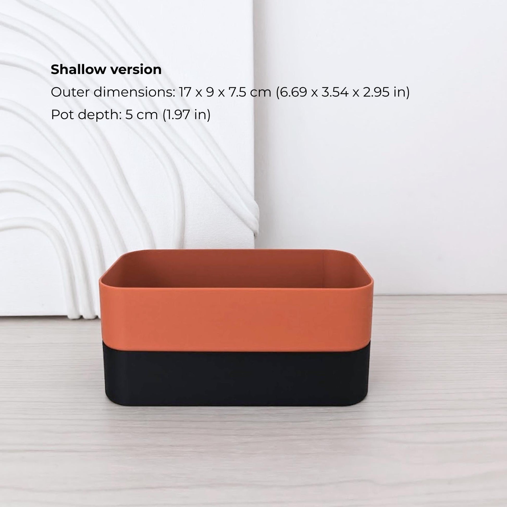 Shallow rectangular self-watering planter assembled in terracotta and black.
