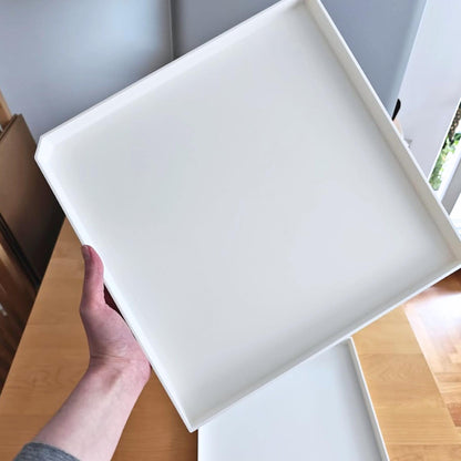 Hand holding drainage tray showing size and thickness
