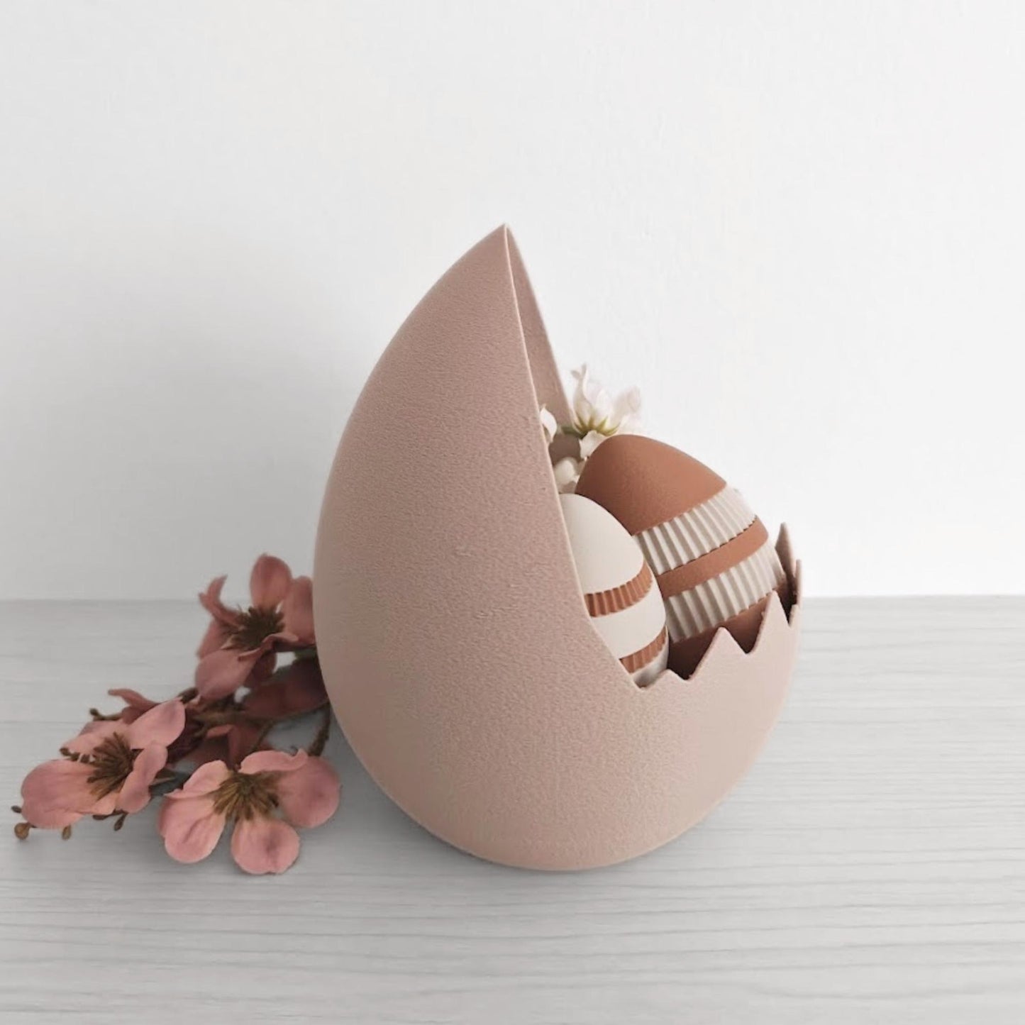 Side view of cracked eggshell basket with eggs displayed inside and floral accent