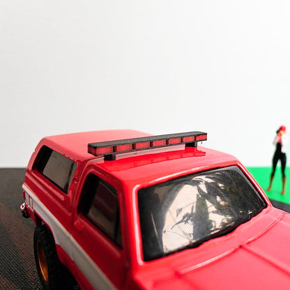 Red diecast SUV with black and red roof light bar mounted