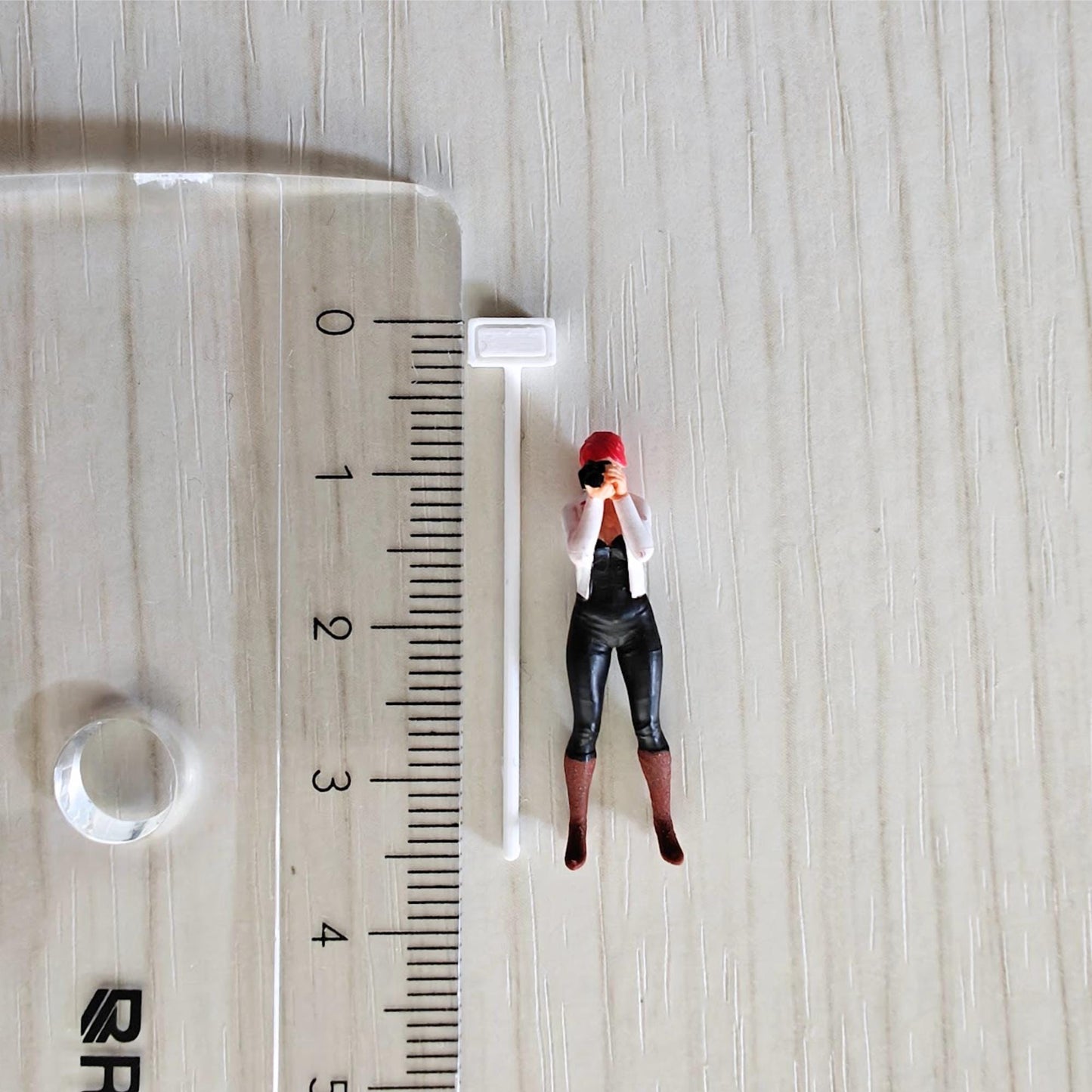 Mini pole floodlight next to ruler and figure for size comparison