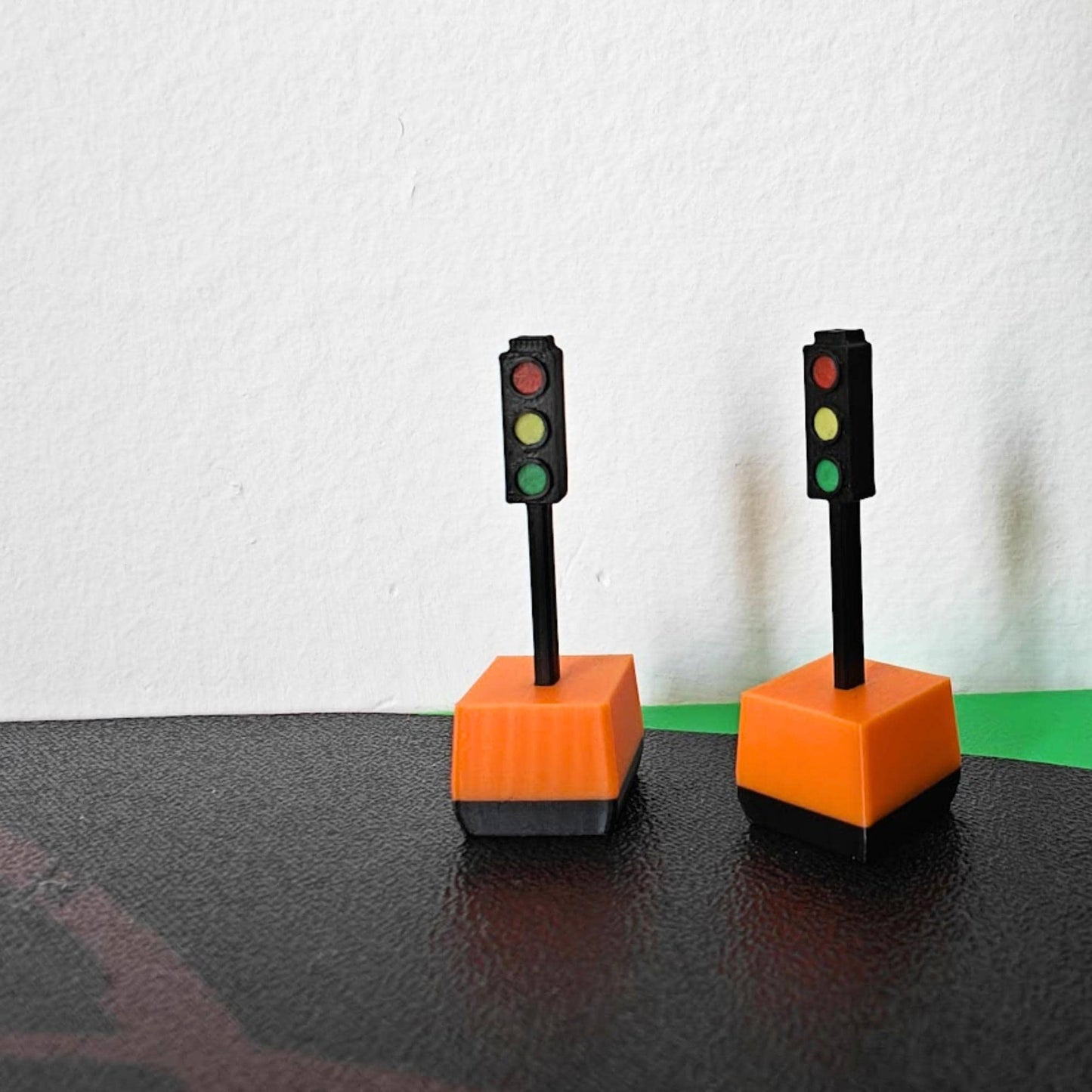 Pair of 1/64 traffic lights with orange bases on curved road display