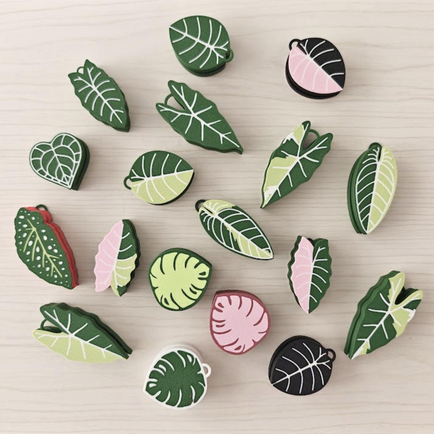 Leaf clicker fidget toys in various plant designs on wooden background