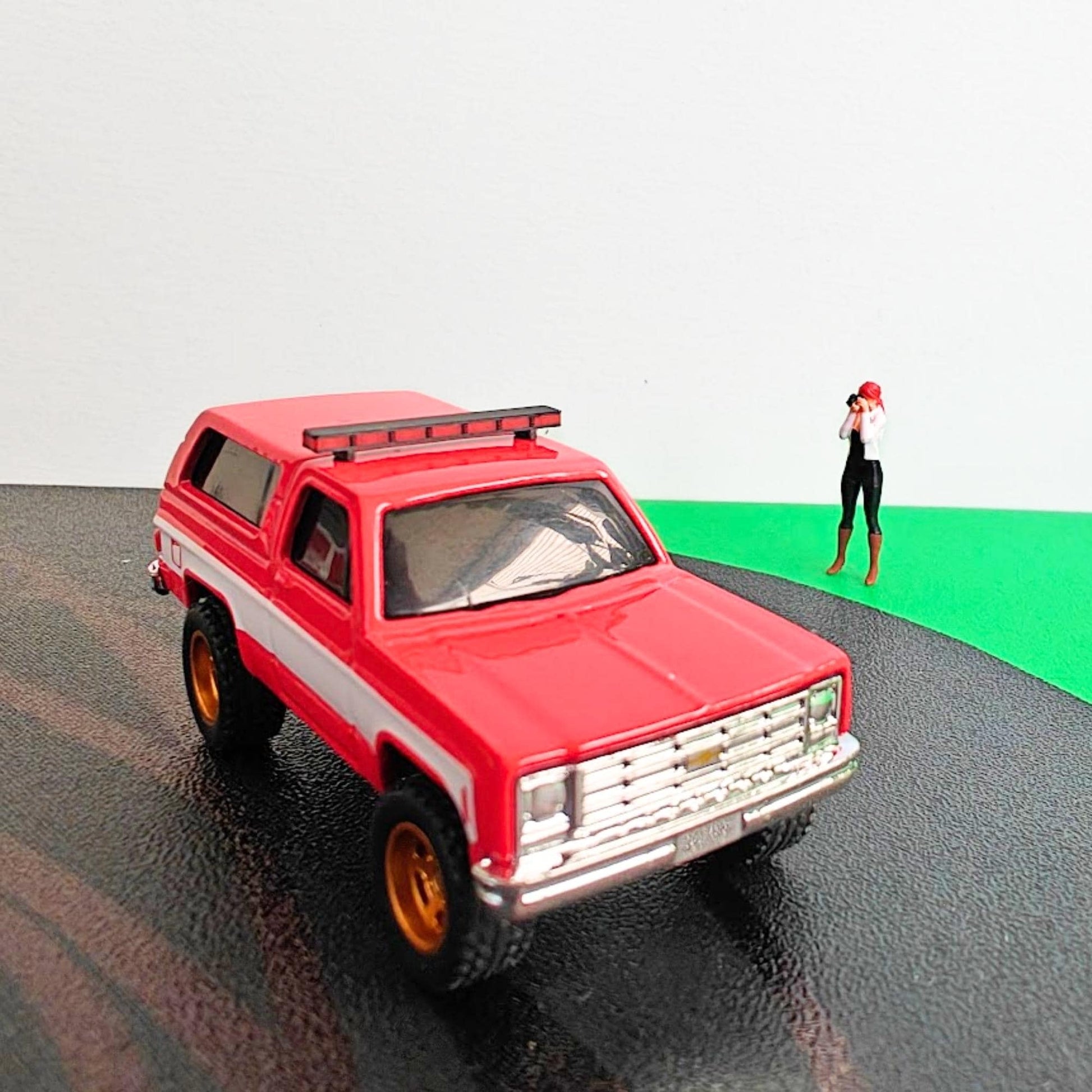 Red diecast SUV with black and red roof light bar mounted