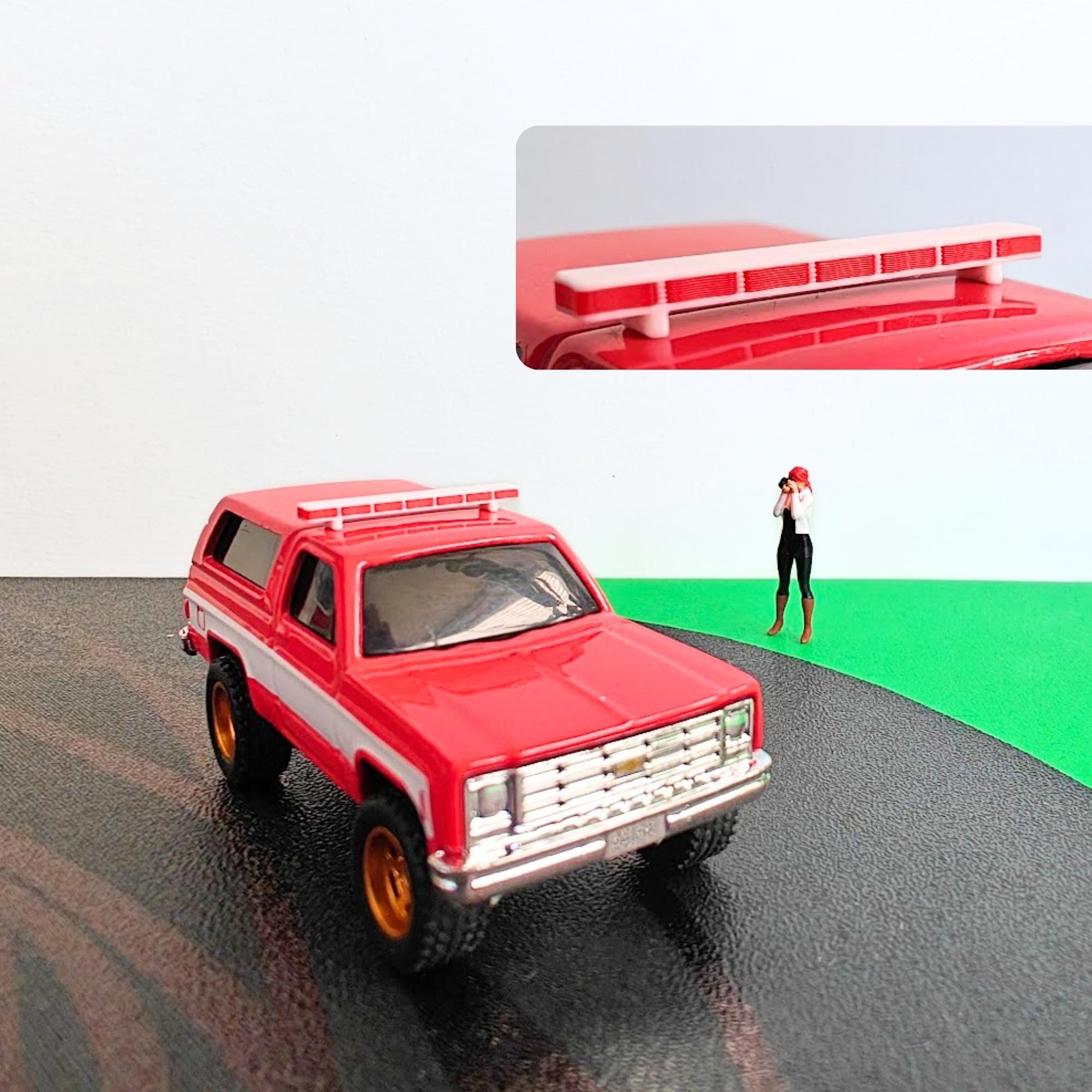 Red diecast SUV with white and red roof light bar mounted