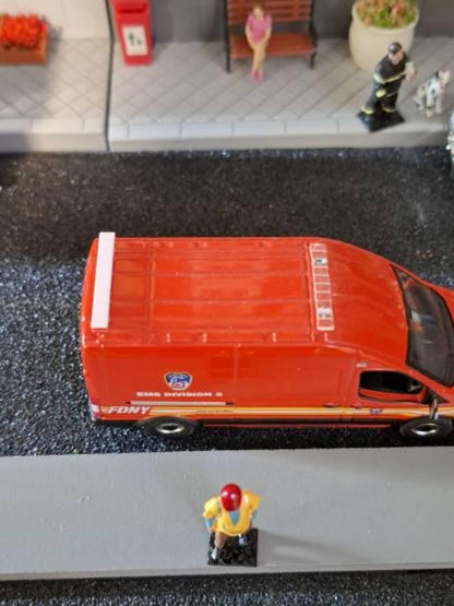 Orange van model with roof light bar driving on textured diorama surface
