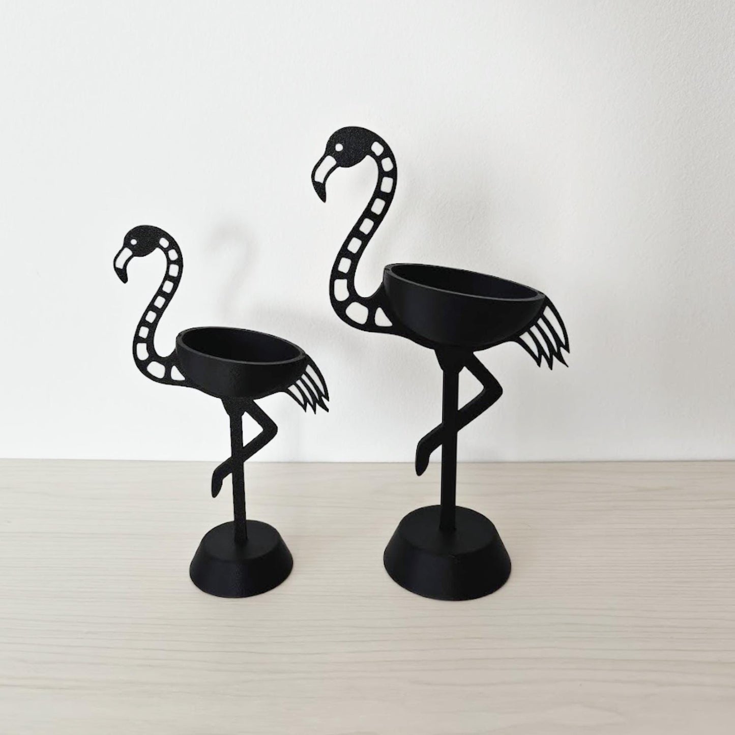 Side profile of both flamingo holders showing curved neck and base
