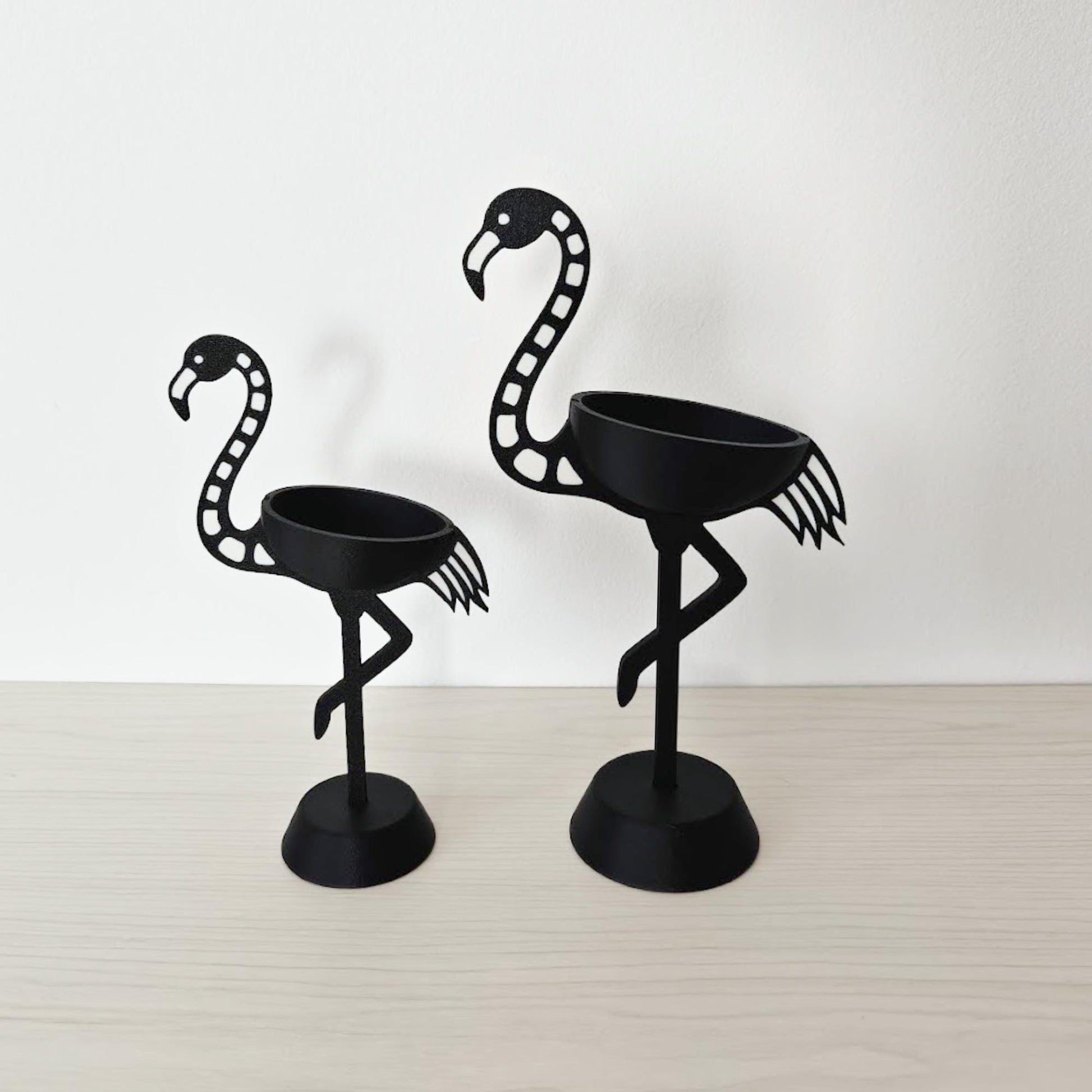 Side profile of both flamingo holders showing curved neck and base