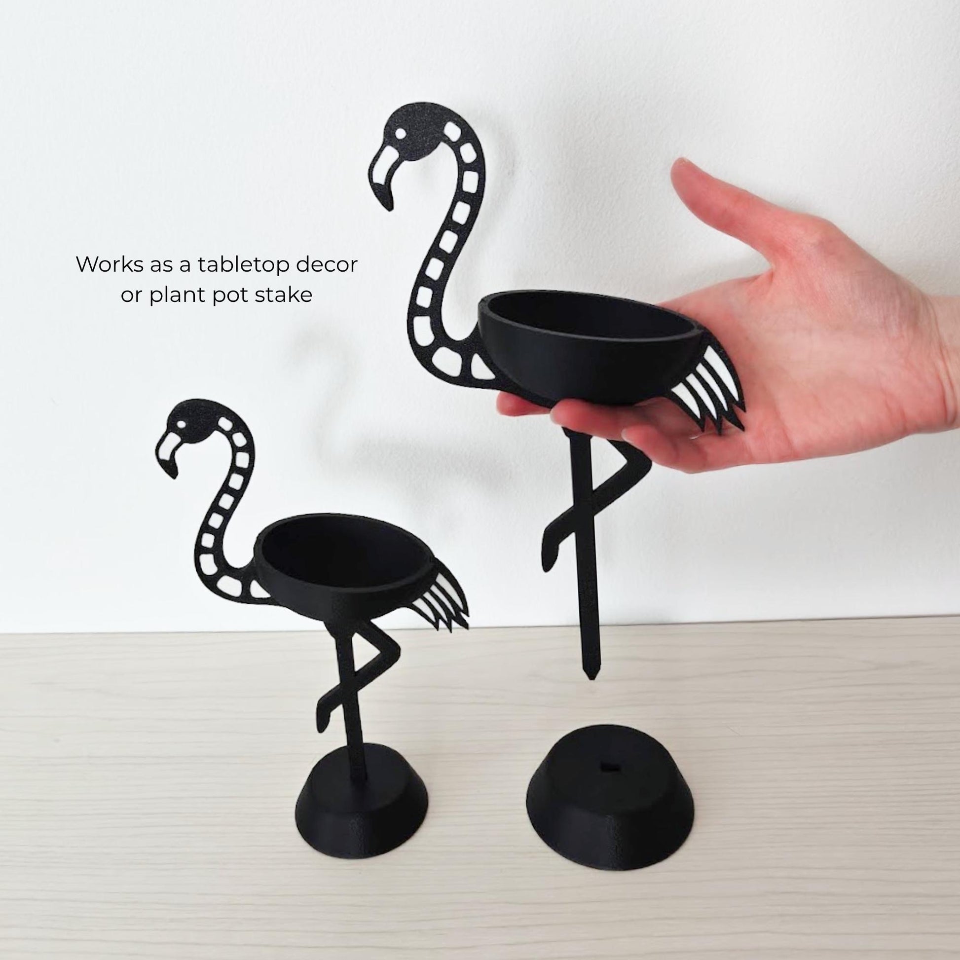 Hand holding small flamingo air plant holder showing that it can be also used as a planter stake