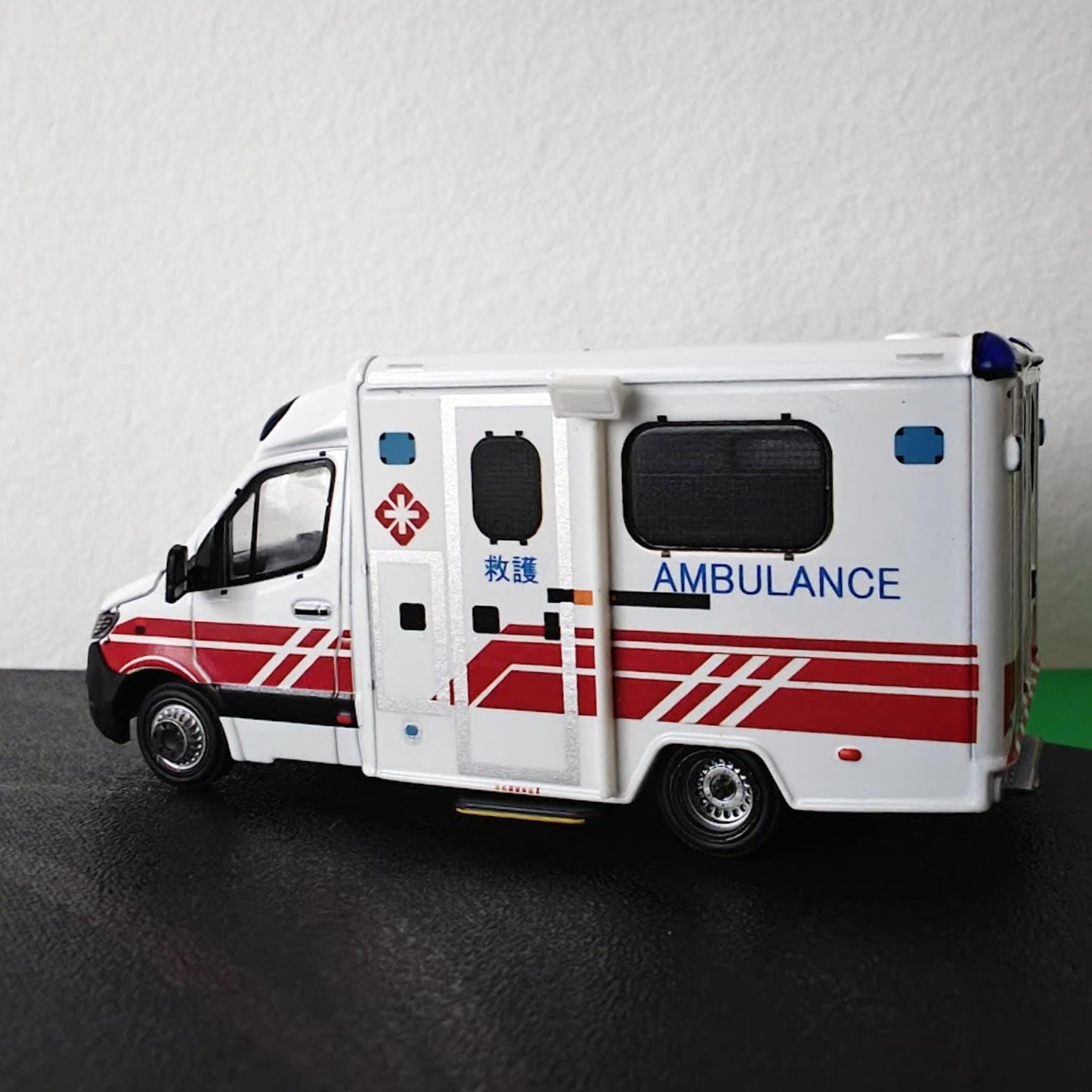 Side profile of 1:64 scale ambulance fitted with roof-mounted scene lighting accessories.