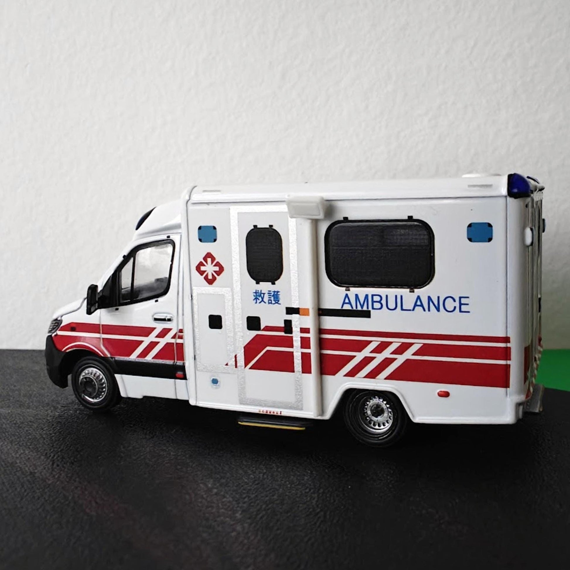 Side profile of 1:64 scale ambulance fitted with roof-mounted scene lighting accessories.