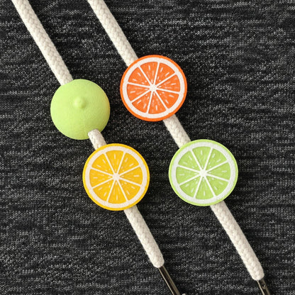 Mixed citrus drawstring charm set with lemon, orange, lime and round beads on white hoodie cords.