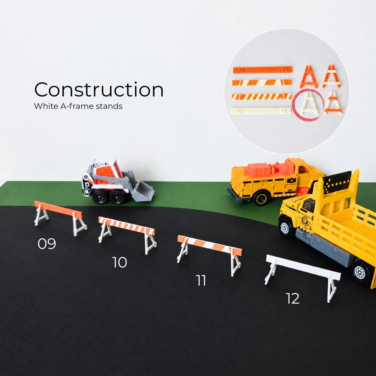 White and orange construction road barriers arranged with miniature construction trucks