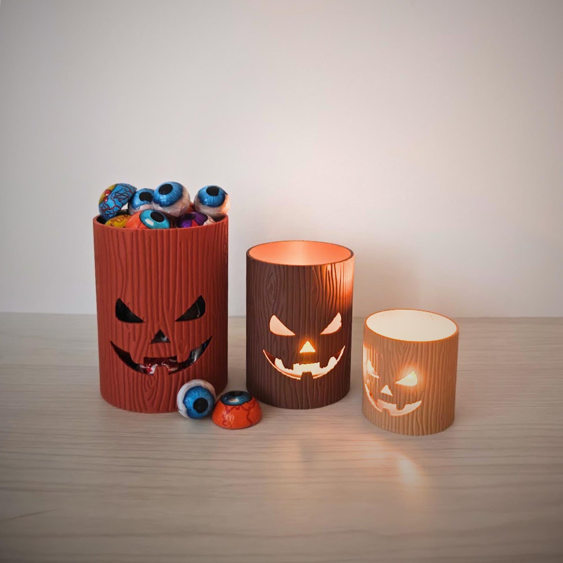 Tree stump jack-o’-lantern trinket holders used as mini storage pots for small items.