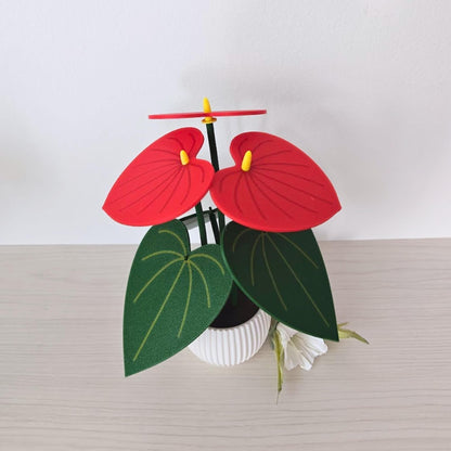 Red Anthurium coaster set displayed in a white pot with removable leaf coasters and 3D printed plant design.