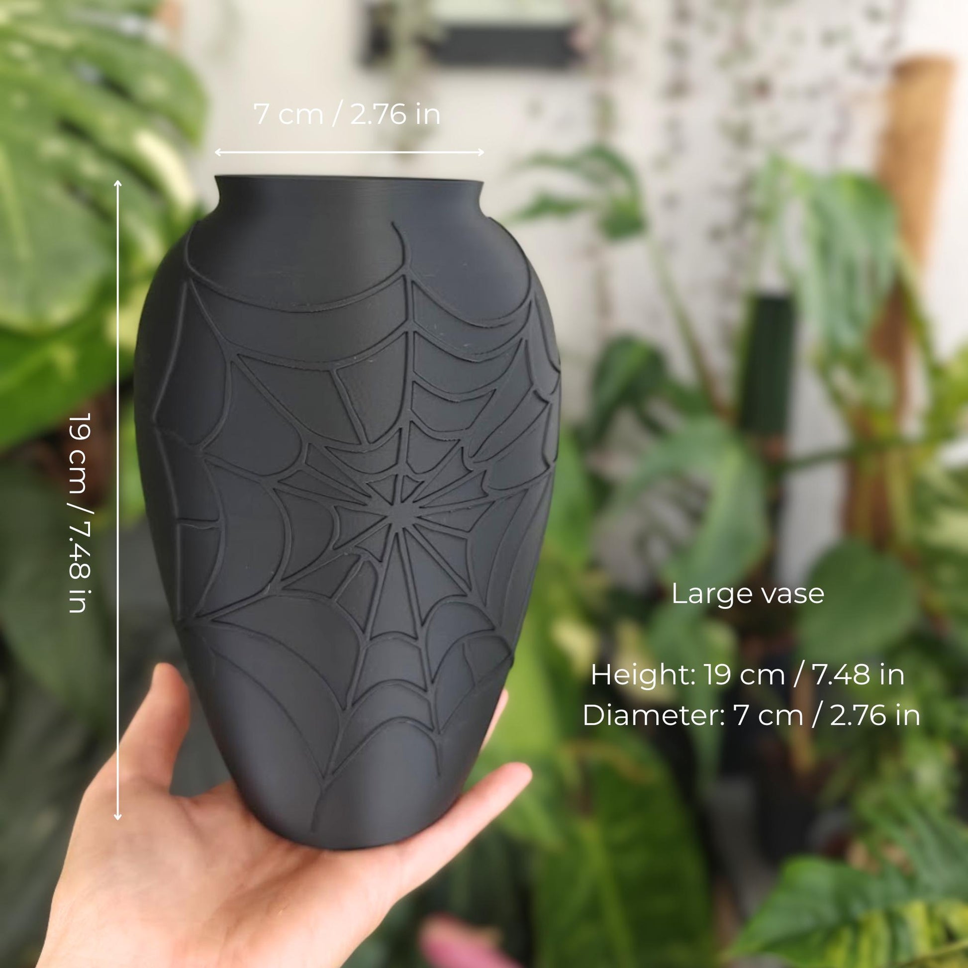 Large black gothic spider web vase shown in hand with size measurements.