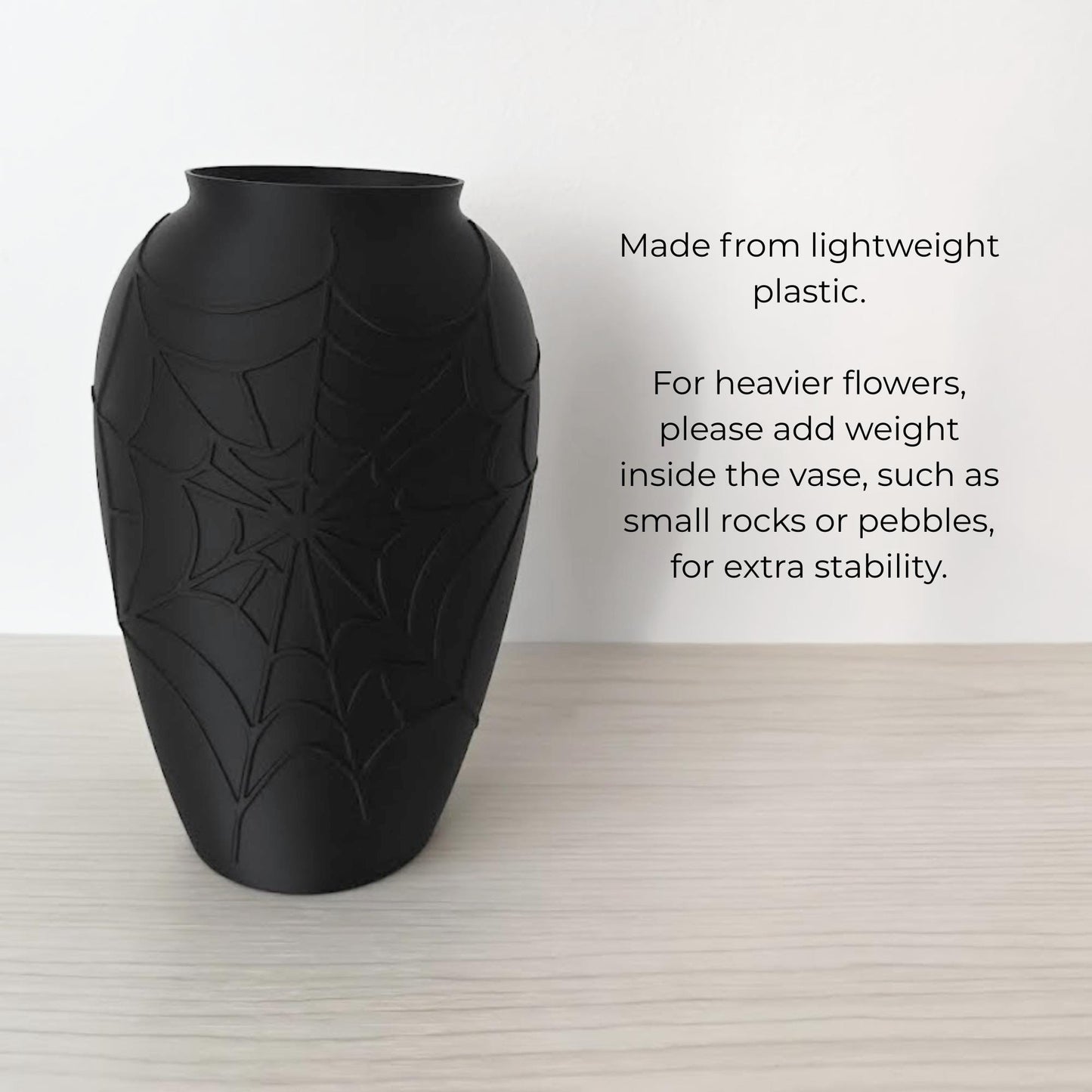 Lightweight black spider web vase with note to add rocks or pebbles for heavier flowers.